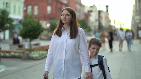 Happy Mom and Son Holding Hands After the Lessons in School