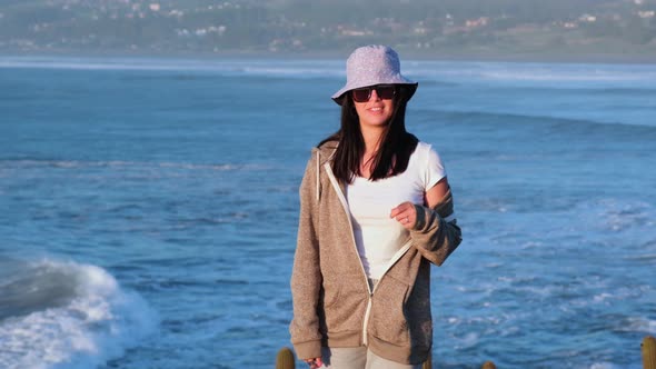 beautiful girl portrait with bucket hat on the beach, pichilemu, punta de lobos. Chilean Latina. mid