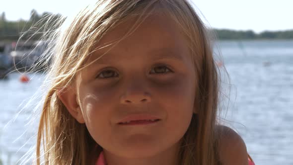 Portrait Of Smiling Young Girl outdoors on bokeh ocean background