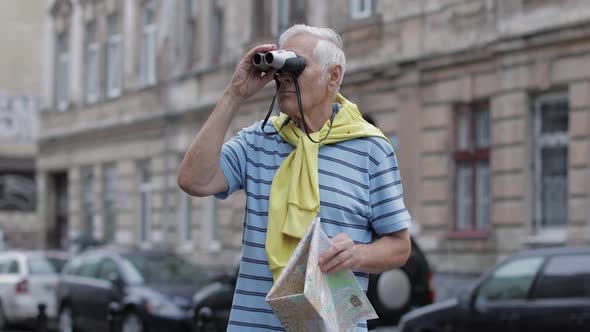 Senior Tourist Exploring Town with a Map. Looking in Binoculars