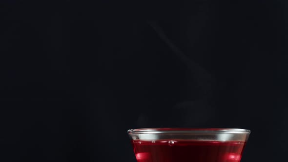 Red Fruit Tea in Glass Cup on Black Background