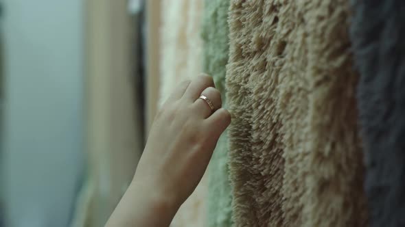 Young Girl Chooses a Cloth in a Store