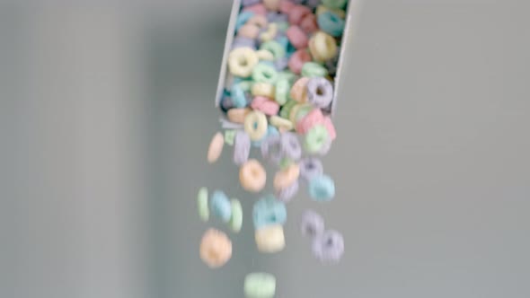 Breakfast Cereals in the Form of Colorful Corn Rings are Poured Out of the Package