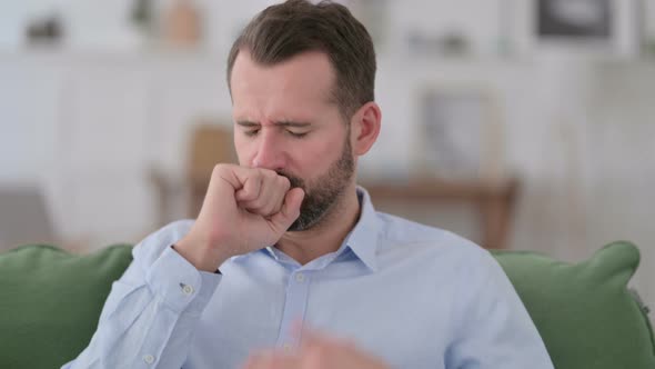 Sick Young Man Coughing at Home 