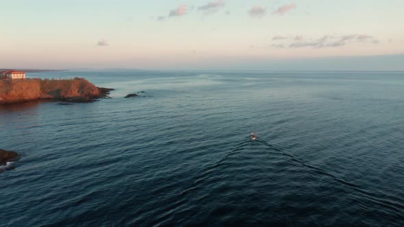 Small boat entering the sea ata sunrise