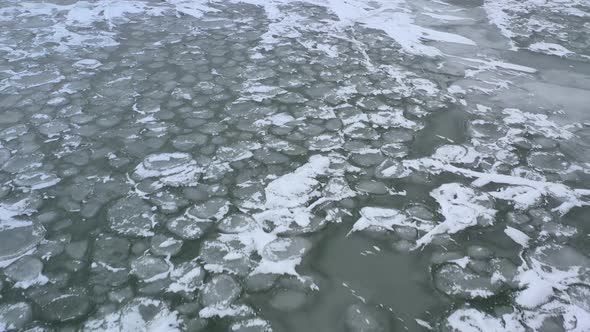 Drone Flying Backwards Above Iced Over Lake In the Wind and Cold. Dusting of Snow over Ice.