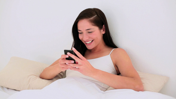 Attractive Brunette Texting On Her Smartphone