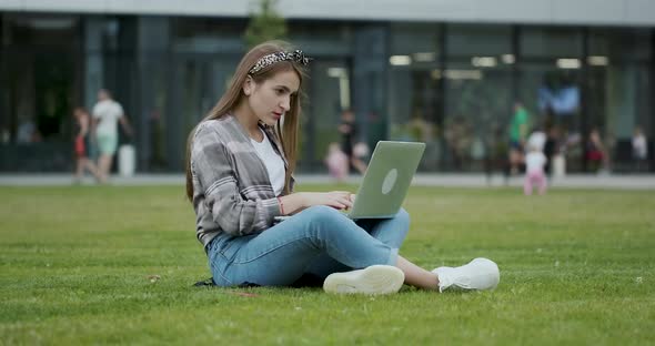 Student Using Laptop Computer while Sitting in Open Air