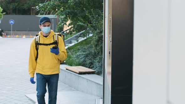 Delivery Man Wearing Protective Mask and Rubber Gloves Ringing a Door