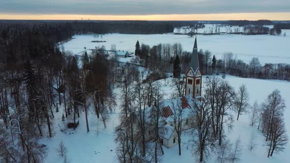 Aerial Top View of the Krimulda Evangelic Lutheran Church in Winter at Sunrise Latvia 4k Video