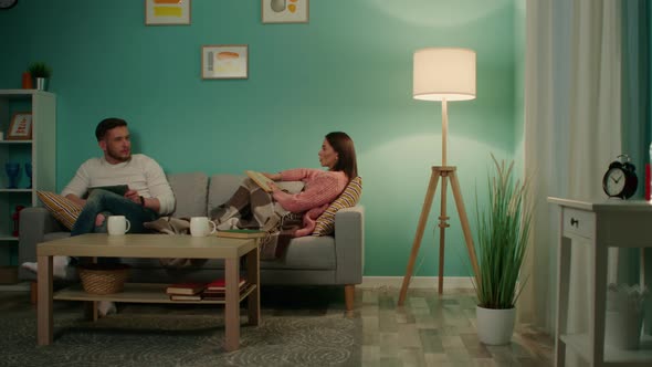 Woman and Man Are Relaxing On Sofa At Home