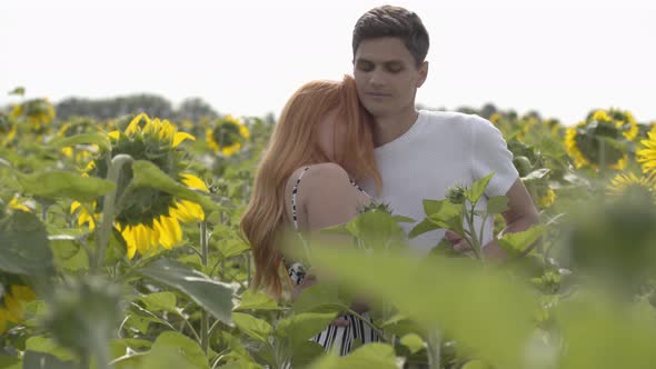 Beautiful Fun Couple Dancing Together on the Sunflower Field, the Woman Spinning Around