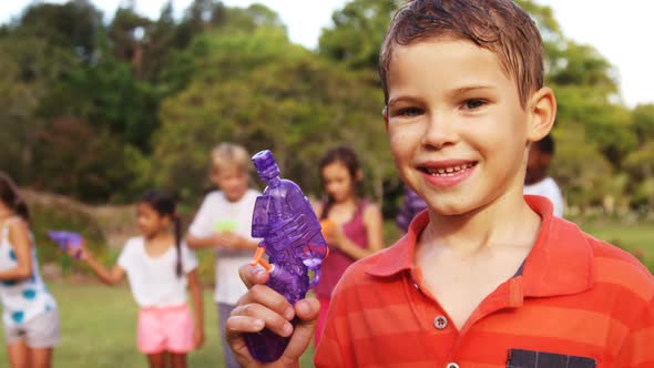 Portrait of smiling boy holding a water gun alt