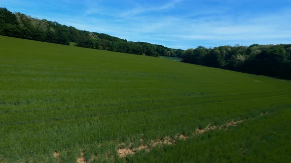 FPV DRONE SHOT - Flight over green field and around a red container