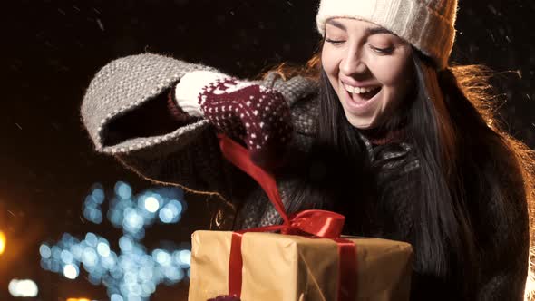 Beautiful Young Girl Unpacks Her Box with a Christmas Gift