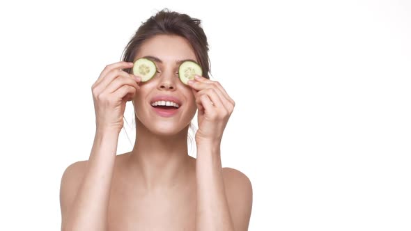 Young Female Model Putting Pieces of Cucumber on Eyes and Dancing Having Fun in Slowmotion Over