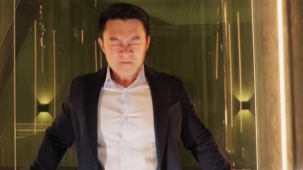 Enraged Angry Asian Business Man Going Up From Office Looking at Smartphone