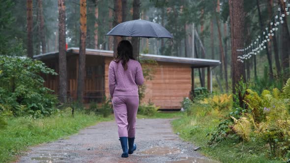Female with Umbrella Enjoying Walking in the Rain