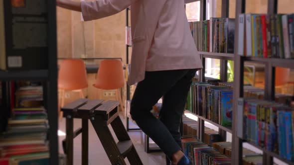 A Young Girl Climbs the Stairs to Get a bookThis Panning Up Video Shows Old Wooden Library Stairs