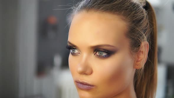 Close Up Shot of Hairstylist Sprays Hairspray on a Model While Making Hairdo