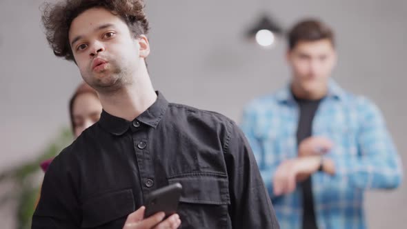 Portrait of Nervous Millennial Middle Eastern Man Waiting in Queue Indoors Checking Time on