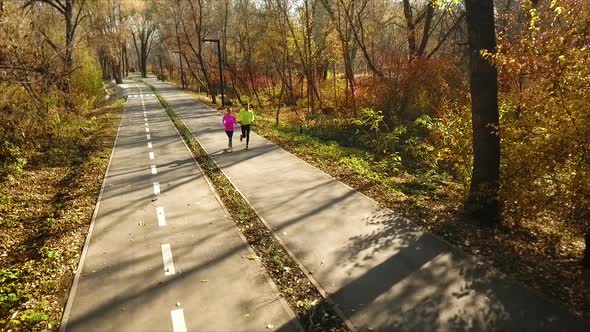 Happy Couple Jogging in Autumn Park in the Morning