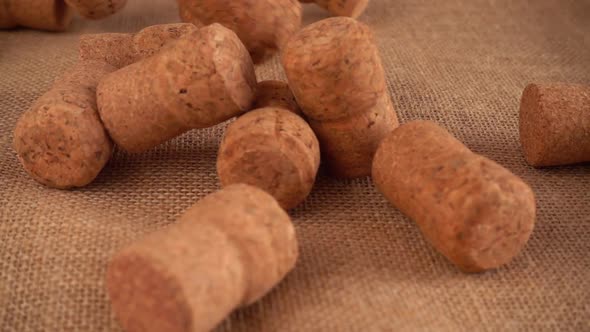 Champagne wine corks fall onto the burlap. Slow motion.