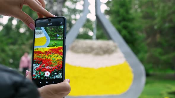 Woman Shoots Video on Smartphone Flowers in the Park Uses Finger Zoom