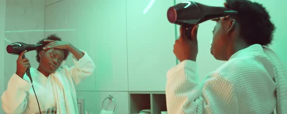 African American Woman Drying Hair in Bathroom