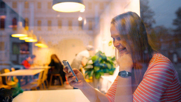 Happy Woman In Cafe Thinking Over Sms She Typing