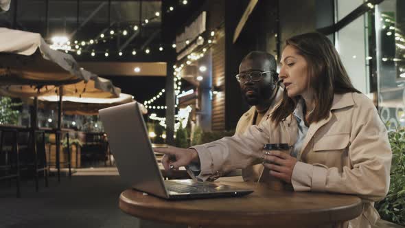 Colleagues At Cafe Table In Evening