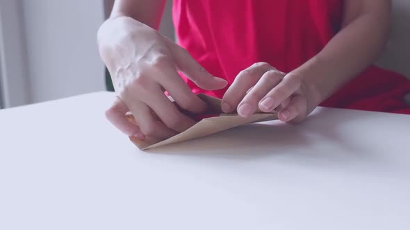 A Woman in a Red Dress Opens a Red Heartshaped Valentine's Delivered Envelope for Valentine's Day