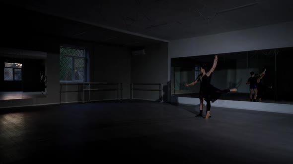 Extreme Wide Shot Dance Studio with Young Man Spinning Woman in Arabesque Position on the Right