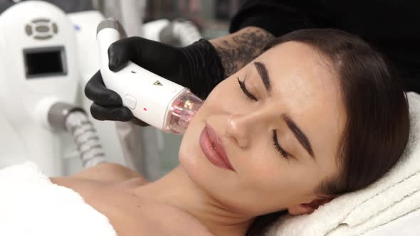 Cosmetologist in Black Gloves Working on Female Face with Beauty Shape