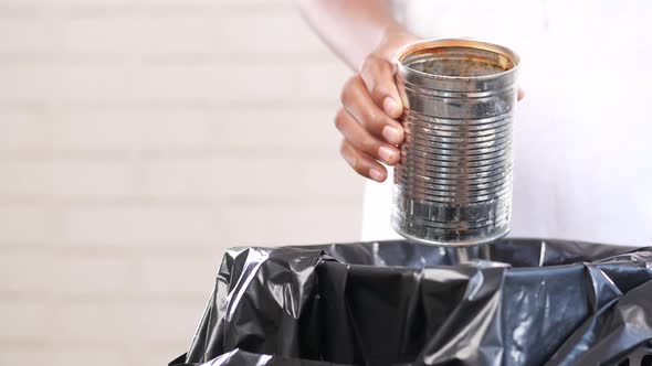 Throwing Tin Container in a Garbage Bin