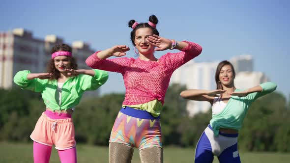 Portrait of Fit Happy Retro Fitness Instructor Training Slim Women Outdoors on Sunny Day