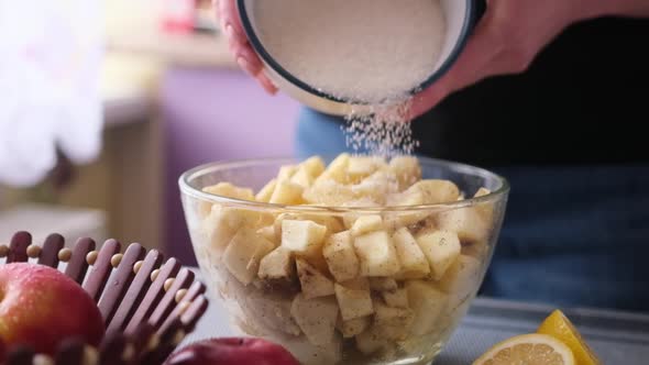 Apple Pie Preparation Series  Woman Adding Sugar to Chopped Apples in Glass Bowl