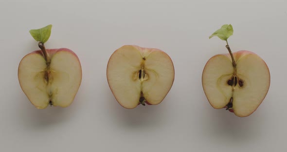 Group of Three Apples Cut in Half with Leaves on a White Background with Lights