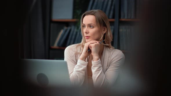 Smart Pensive Business Woman Professor Teacher Thinking Planning Analyzing Working at Library Laptop