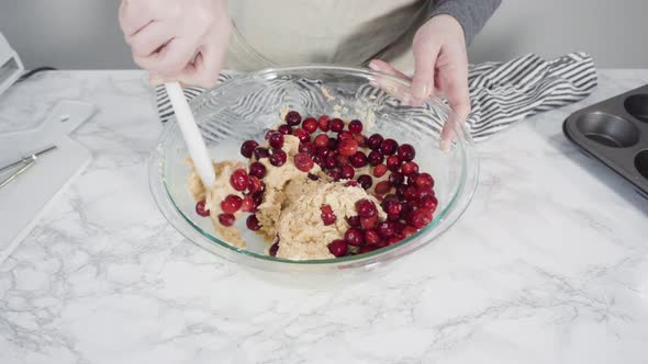 Step by step. Mixing ingredients in a mixing bowl to bake cranberry muffins