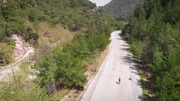 Cyclist riding bike on country road in mountains. 