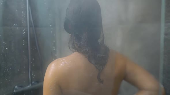 Woman Washes Her Hair Shoulders Arms and Back in the Shower