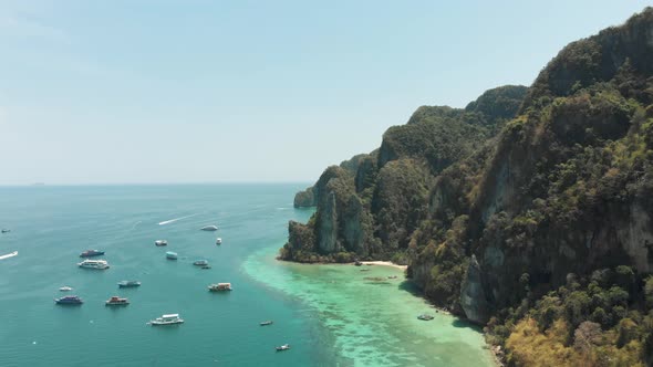 Towering Limestone stalled by shoreline winding around Ko Phi Phi Don Island Paradise, Thailand