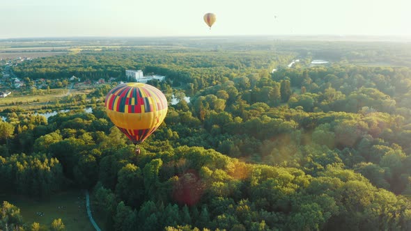 Beautiful Scene of the Balloon Gaining Height Above a Public Park or Forest. Hot Air Balloon Flies