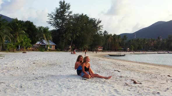 Girls happy and smiling on marine sea view beach journey by aqua blue ocean with white sandy backgro