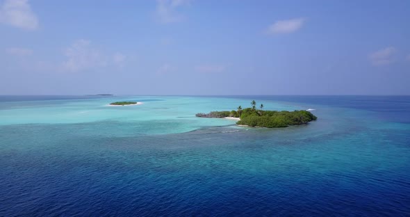 Wide aerial tourism shot of a white paradise beach and blue ocean background in colorful 4K