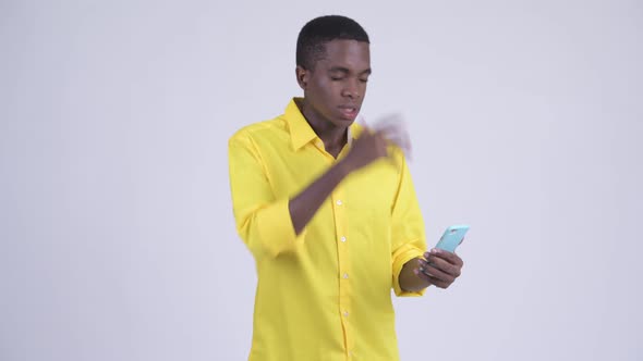 Young Stressed African Businessman Using Phone and Getting Bad News