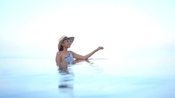 Young asian woman enjoy around outdoor swimming pool for leisure