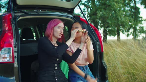 Women Tourists Looking Through Binoculars at View