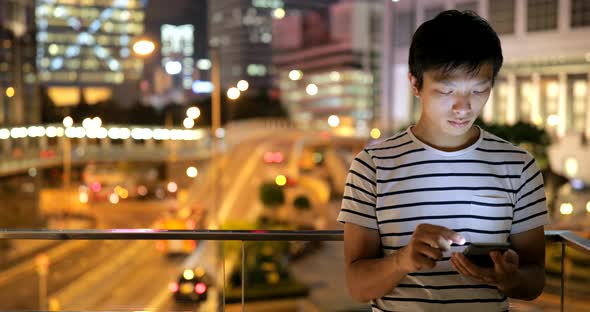 Young man using smart phone in city